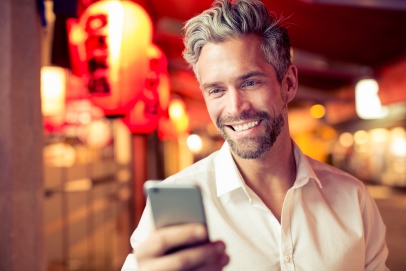 Mann schaut auf sein Smartphone in der Hand