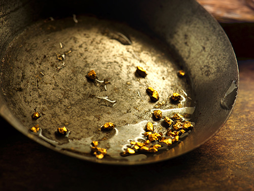 Goldnuggets in einer Metallschuessel