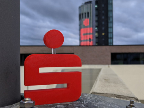 Das kleine Sparkassen S platziert vor dem Sparkassen-Turm der Sparkasse Pforzheim Calw